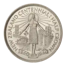 A coin featuring the Coat of Arms of New Zealand, surrounded by Maori wood carvings and the encircling text "NEW ZEALAND HALF CROWN 1933."