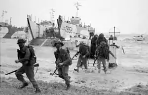 men wading ashore from landing craft