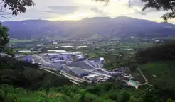 cluster of buildings surrounded by green fields and hills