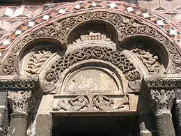 The carving of the polychrome porch of the Saint-Michel-D'aiguilhe chapel, the Aiguilhe, Haute-Loire, France, (11th century), has paired mermaids, and the Lamb of God