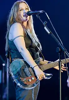 Alanis Morissette onstage, singing and playing guitar