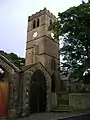 The tower of the old church with the coach house in the foreground