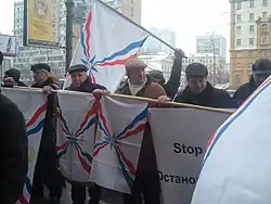 Warmly-dressed men holding Assyrian flags