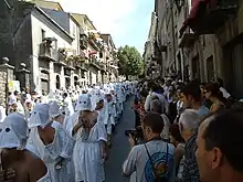 A Christian procession with penitents mortifying the flesh with spugnas in the Italian city of Guardia Sanframondi