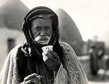 Image 29Syrian Bedouin from a beehive village in Aleppo, Syria, sipping the traditional murra (bitter) coffee, 1930 (from History of coffee)