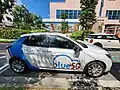 Bluesg Corsa-e parked at a station.