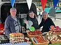 Egg seller and family in the rain at St Albans Market.