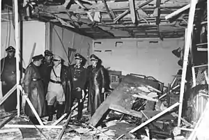 Several people looking inside a destroyed room