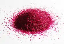 a pile of red granules on white paper