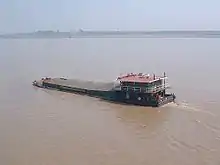 Self-propelled barge carrying bulk crushed stone