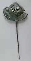 Disk pin; face with one remaining inlaid eye