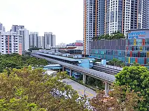 The station with a blue exterior is located in the median of the main road, surrounded by other buildings