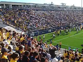 Football fans standing in the bleachers of a stadium