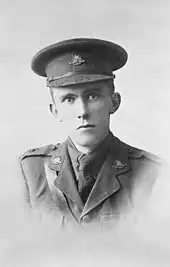 Head and shoulders of a young man in uniform, wearing a peaked cap.