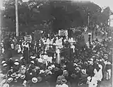 Crowds of people watching a catafalque pass by