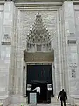 The entrance to the mosque, featuring a carved muqarnas portal