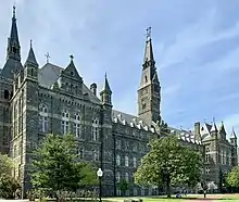 A large Gothic-style stone building dominated by a tall clocktower.