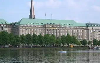 A multi-storey office building in front of a waterbody.