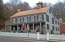 The house viewed from its left. In this image the roof has wooden shingles