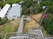 A downwards view of a long staircase down the side of a hill