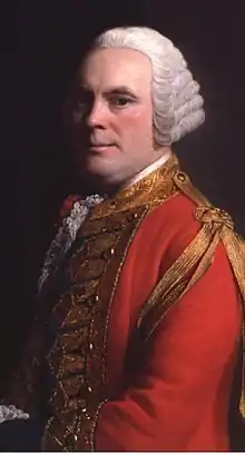 Half-length portrait of a man against a dark background. He is wearing a red military jacket with a gold tassel on the right shoulder. His body is facing three-quarters right, but he is looking straight ahead.