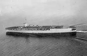 Aircraft carrier on the sea with cloudy sky in the background