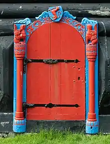 The entrance of Roykstovan was destroyed in 1833. This true to original copy was timbered and carved by the King's Farmer Jóannes Patursson in 1907. On the top is the Norwegian Lion, indicating that the Faroes were a Norwegian colony after the Viking age.