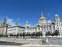 Three large white buildings with varying styles.