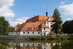 Lnáře Stronghold and Lnáře Castle (in the background) on the shore of Zámecký Pond