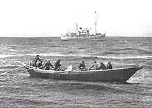 USFS Penguin (background) at anchor in the Bering Sea in 1939 while she unloads off St. George Island in the Pribilof Islands.