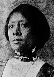 A black and white photograph of a negro woman wearing a high-collard blouse.