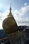 Male Buddhists are allowed to paste gold leaf onto the rock, as a sign of devotion