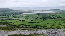 View northwest from Turlough Hill, with the Oughtmama churches at the foot of the hill, Corcomroe Abbey, two ruined castles and the Finavarra Martello Tower in the back