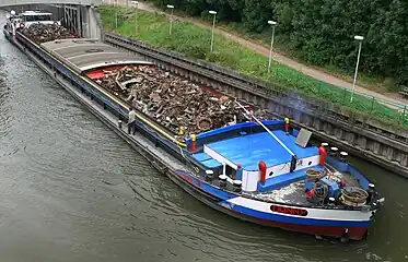 A self propelled barge carrying recycling material on Deûle channel in Lambersart, France