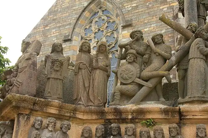 Veronica holds up her veil bearing Jesus' image, Saint John and the Virgin Mary follow Jesus carrying the Cross, assisted by Simon and between them and Jesus three soldiers play instruments.