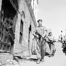 Parachute Regiment soldiers in Aden in 1956 wearing khaki drills and berets, with carrying equipment stripped to ammunition pouches.