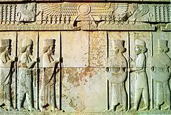 Stone relief depicting two groups of three men facing each other (from Human history)