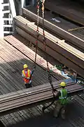 Labor union workers unload structural steel from the hold of a ship