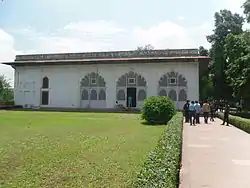 Simple white building, with persons on walkway