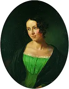 Portrait of a young lady, over a black background. She is wearing a green dress, over a black coat. She is looking to the left, somewhat smiling.