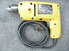 Yellow plastic household type electric drill with black coiled flexible cord