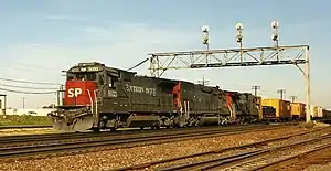 SP 8033, a Dash 8-39B, leads an EMD SD40T-2 and another GE locomotive westbound through Aurora, Illinois.