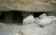 Portico of the tomb, columns half buried in the sand.