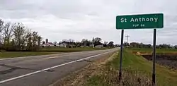 highway sign reading St. Anthony population 86 with the small town in the distance