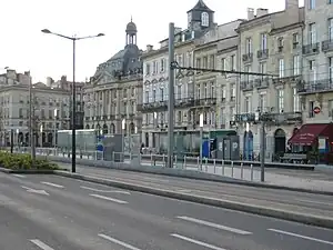 Shelters on side platforms in front of a row of buildings