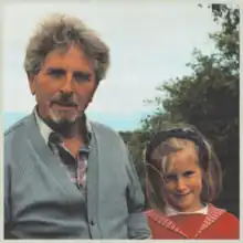 A vintage-styled photograph of a man and a girl looking at the camera.