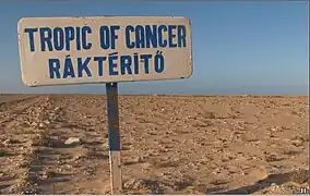 Road sign south of Dakhla, marking the Tropic of Cancer. The sign was placed by Budapest-Bamako rally participants; thus, the inscription is in English and Hungarian.