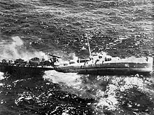 USS Fiske broken in two and sinking in the Atlantic Ocean on 2 August 1944 after she was torpedoed by the German submarine U-804. Note the men abandoning ship by walking down the side of her capsizing bow section.