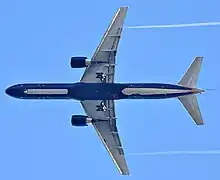 Aircraft in flight, underside view. The jet's two wings have one engine each. The rounded nose leads to a straight body section, which tapers at the tail section with its two rear fins.