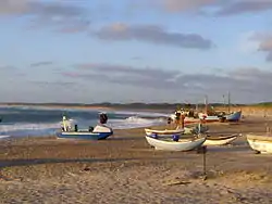 The landing site with small fishing dinghies at the front and larger coastal boats in the background